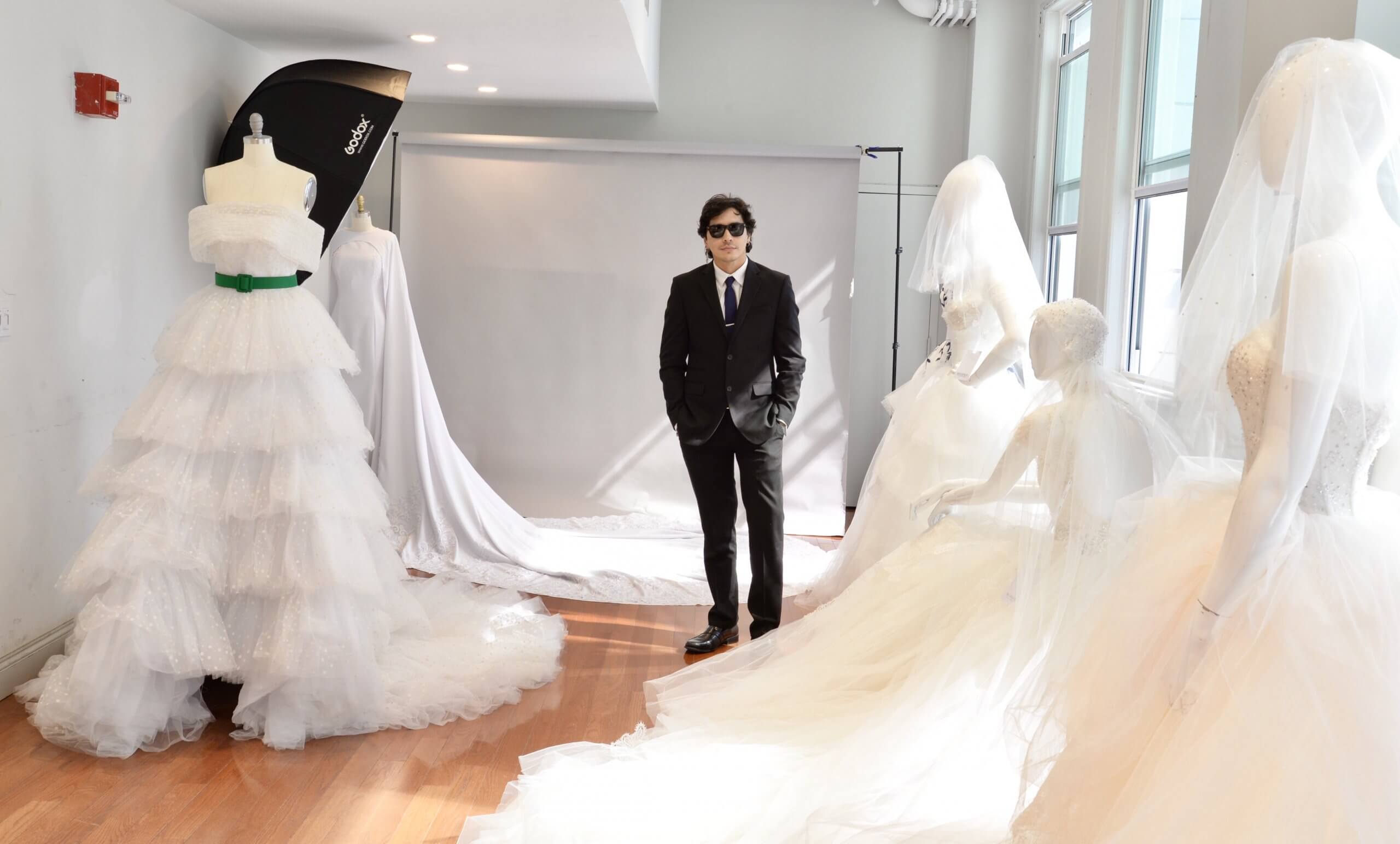 Guillermo Pharis standing with dresses